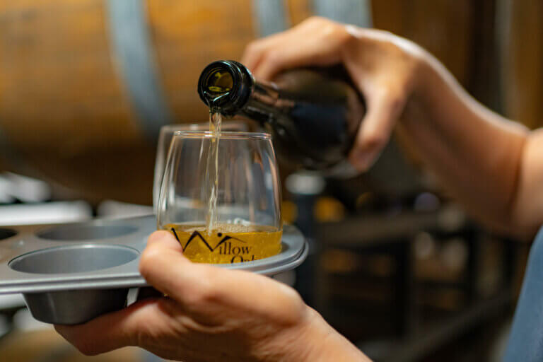 Photo: A stream of golden cider flows from a bottle into a Willow Oaks glass.
