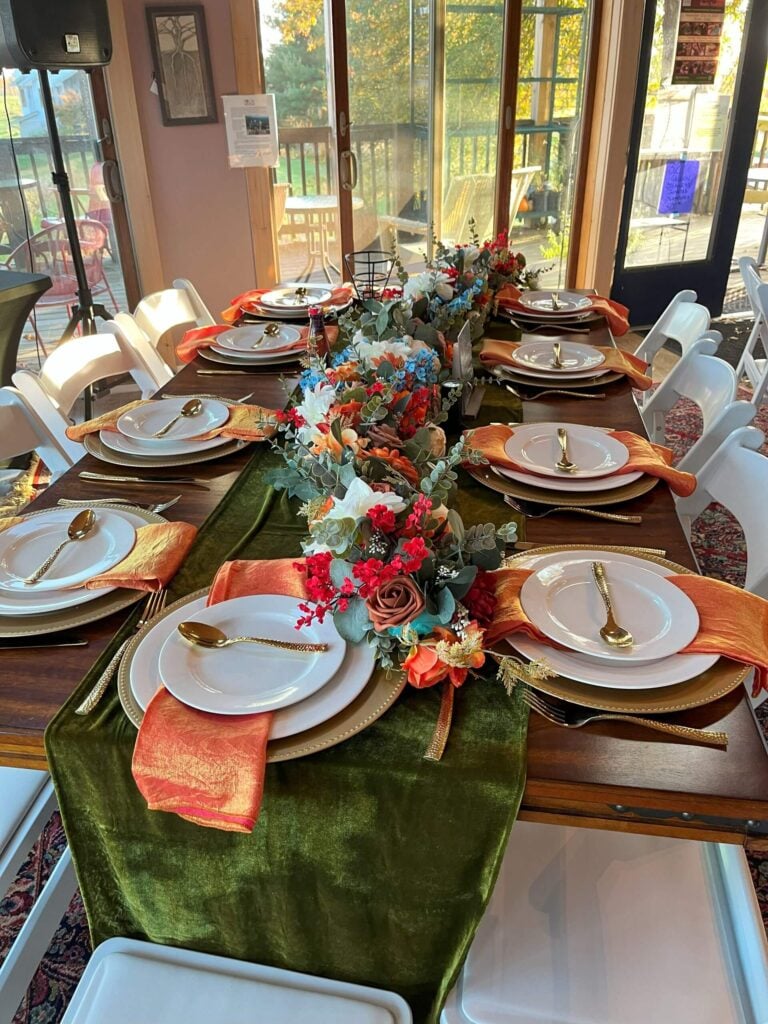 A beautiful formal dining set-up with colorful linens and flowers at Willow Oaks craft cider.