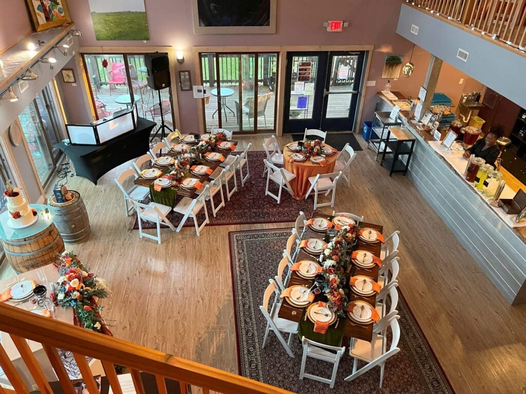 Several long tables set up for a formal party in the tasting room at Willow Oaks craft cider.
