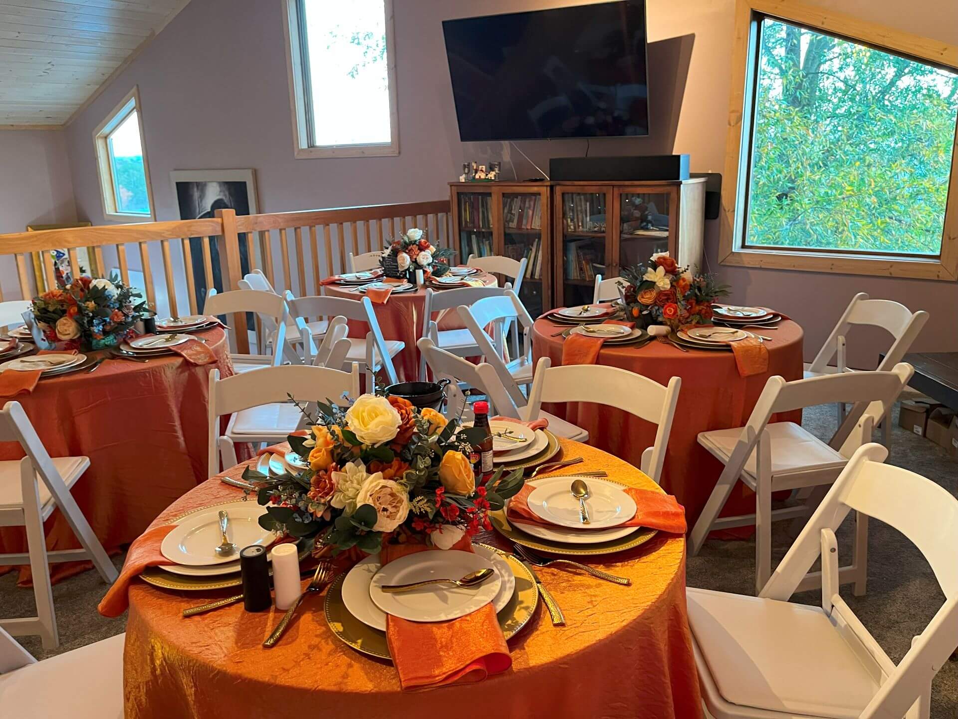 Several found tables set up for formal dining with colorful linens and flowers at Willow Oaks craft cider.